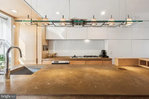 a kitchen with stainless steel appliances granite countertop a sink dishwasher a stove and white cabinets with wooden floor