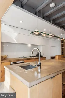 a kitchen with a sink a counter and chairs