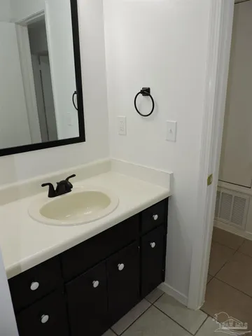 a bathroom with a sink vanity and a mirror