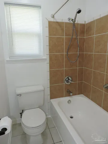 a white bath tub sitting next to a toilet