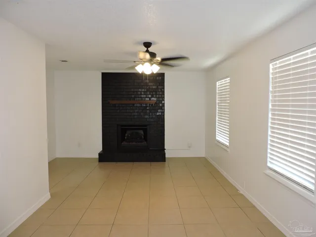 a living room with a fireplace furniture a chandelier and a window