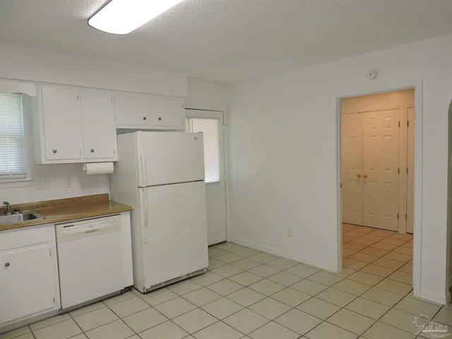 a view of a kitchen with white cabinets