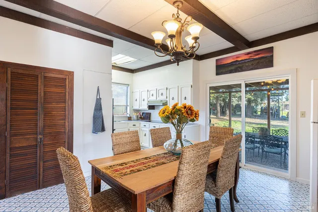 a view of a dining room with furniture a chandelier and wooden floor