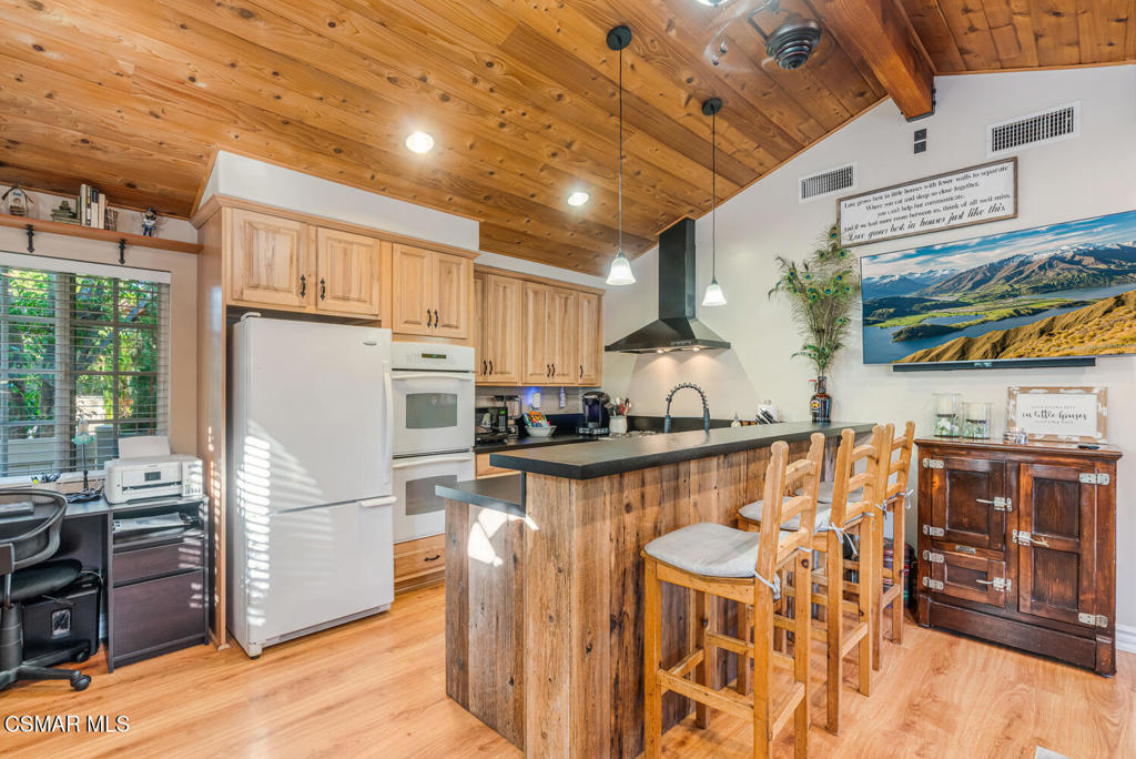 1088 Alta Vista Road Simi Valley, CA 93063 - Photo 12 of 24 a kitchen with stainless steel appliances granite countertop a refrigerator a stove a sink dishwasher and white cabinets with wooden floor