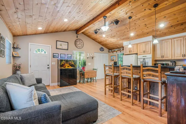 a living room with furniture kitchen view and a large window