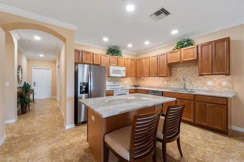a kitchen with a table chairs refrigerator and microwave