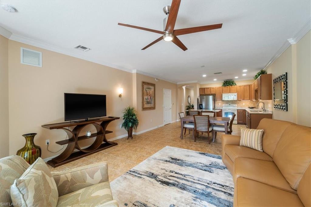 14981 Reflection Key Circle, Unit 322 Fort Myers, FL 33907 - Photo 7 of 35 a living room with furniture and a flat screen tv with wooden floor