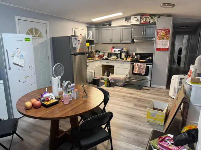 a kitchen with stainless steel appliances a dining table and chairs