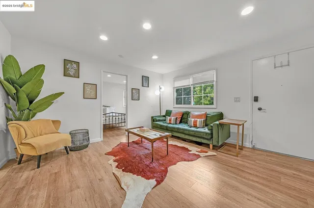 a living room with furniture a wooden floor and a potted plant