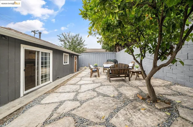 a view of house with patio outdoor seating and covered with trees