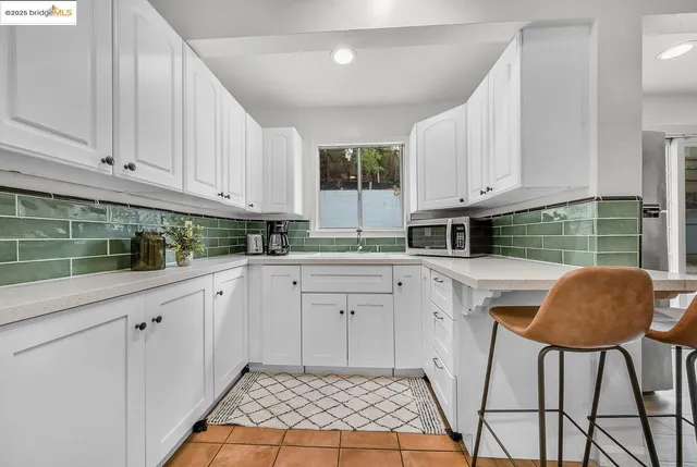 a kitchen with granite countertop a white cabinets and window