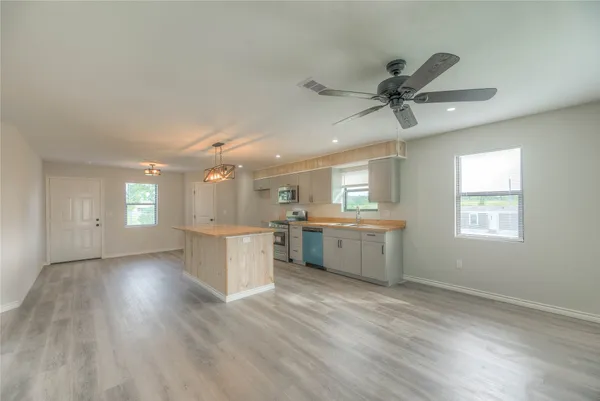 a kitchen with stainless steel appliances granite countertop a sink a stove and a wooden floors