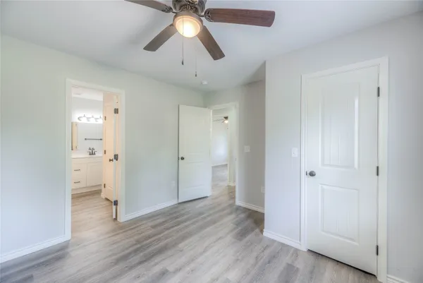 an empty room with a window and a fan