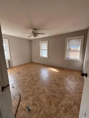 an empty room with windows and fan