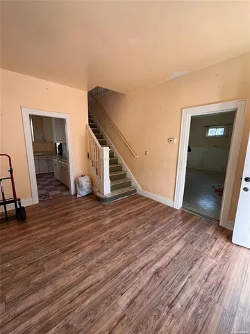 a view of a livingroom with wooden floor and stairs