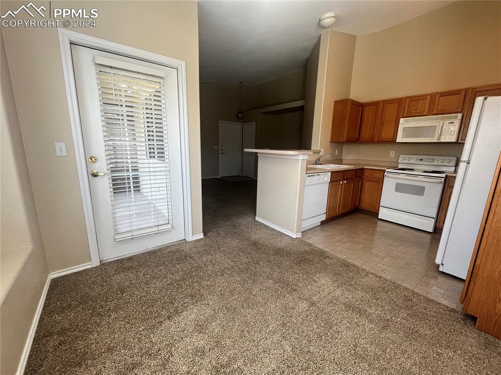 3731 Riviera Grove, Unit 203 Colorado Springs, CO 80922 - Photo 11 of 22 a view of a kitchen with refrigerator and stove