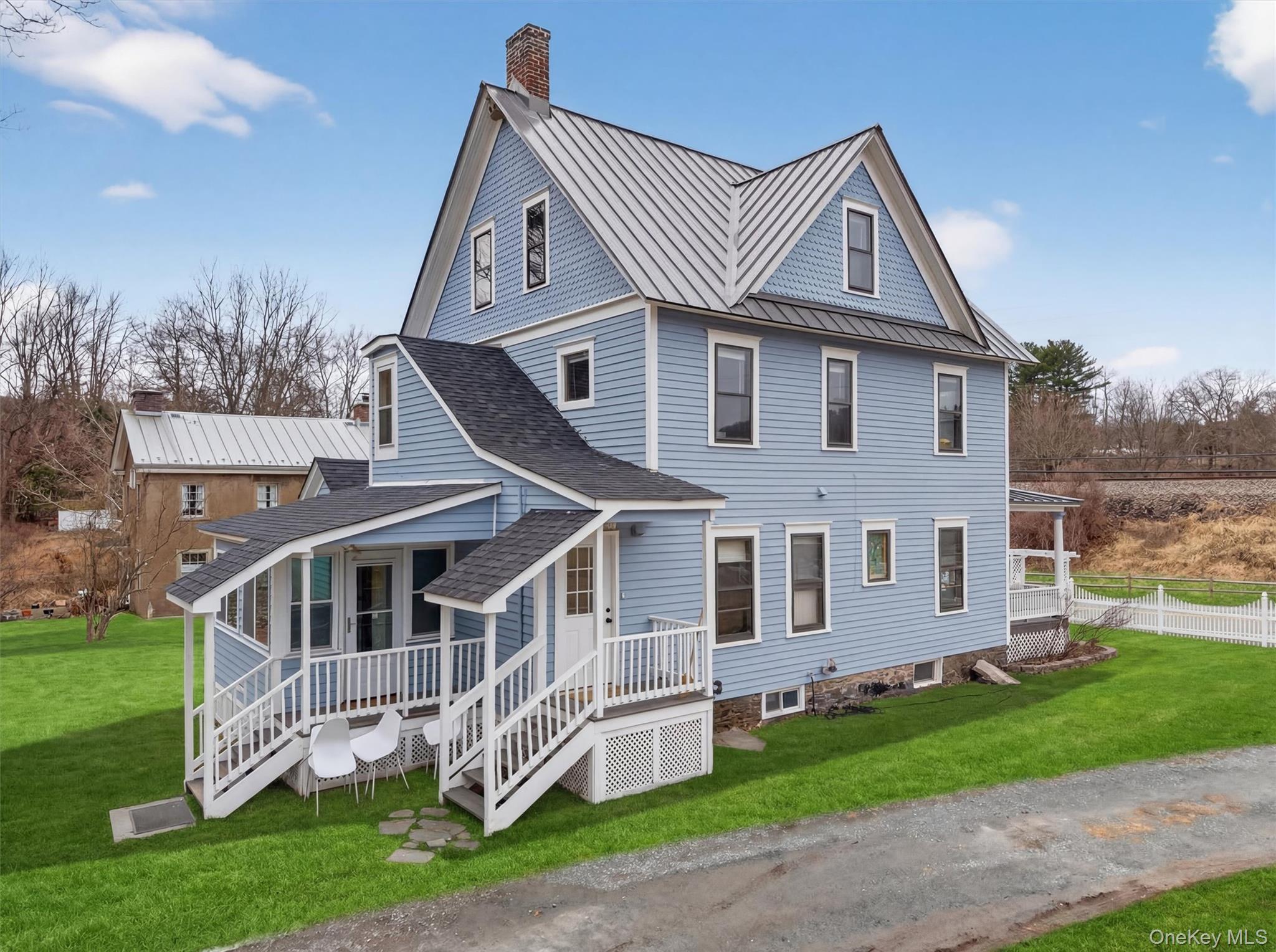 48 Kirks Road Narrowsburg, NY 12764 - Photo 38 of 50 View of front facade featuring covered porch, a chimney, a shingled roof, and a standing seam roof