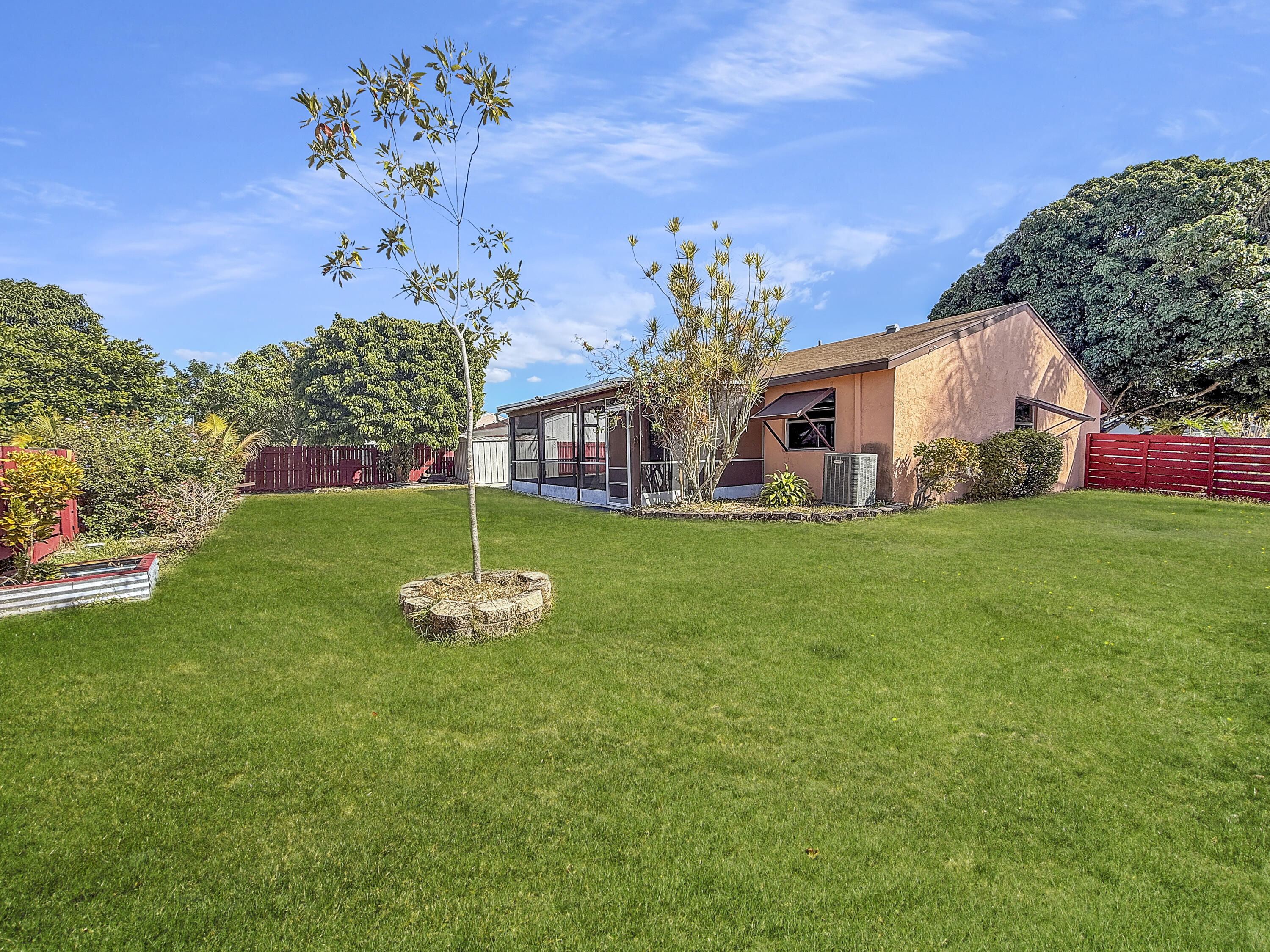 4387 Appian Way Greenacres, FL 33463 - Photo 2 of 14 a front view of a house with garden