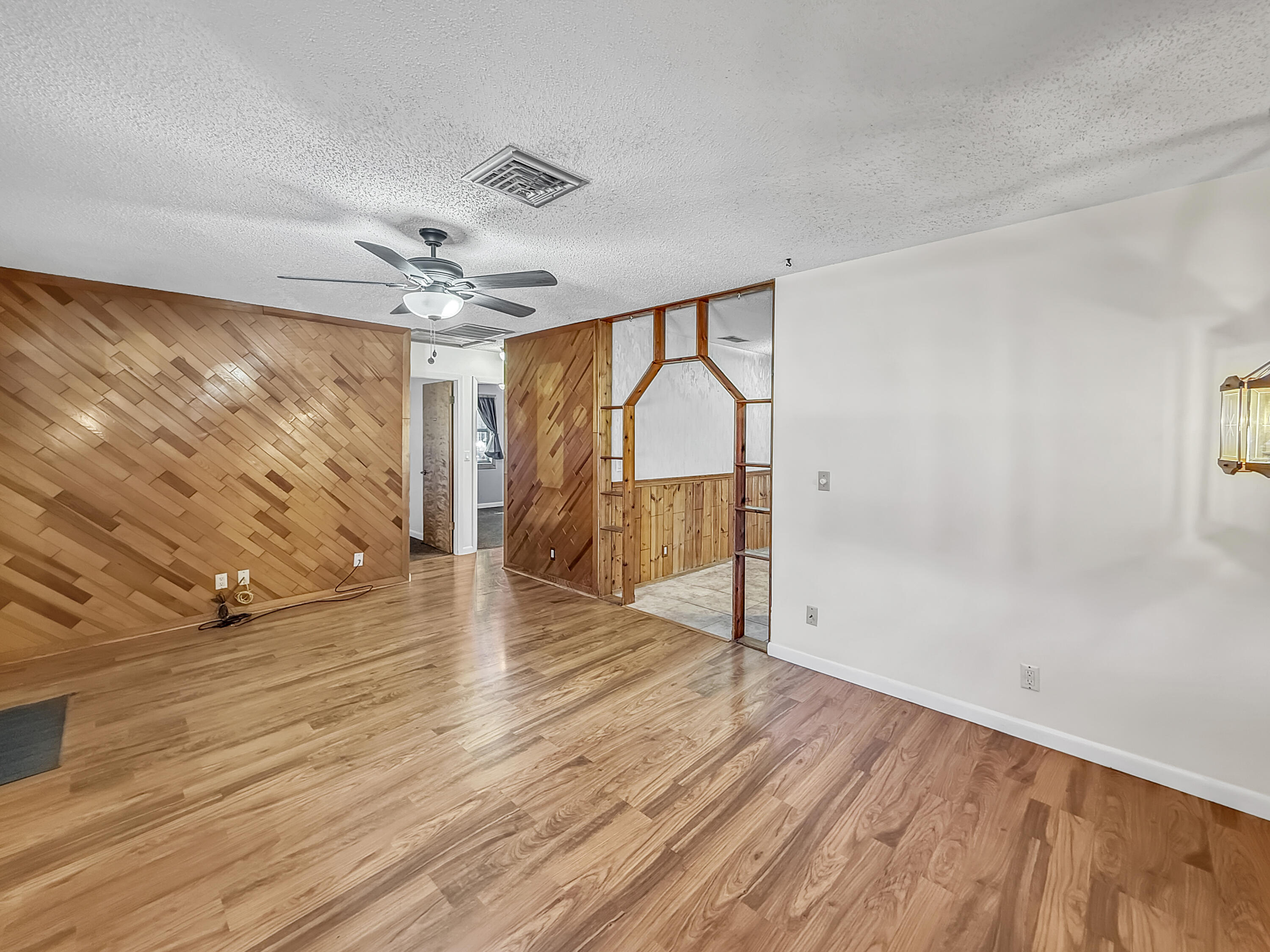 4387 Appian Way Greenacres, FL 33463 - Photo 4 of 14 a view of an empty room with wooden floor and fan
