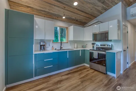 a kitchen with sink a microwave and cabinets