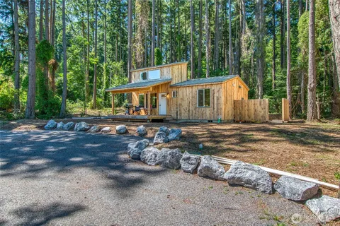 a view of a small house with large trees