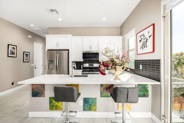 a kitchen with stainless steel appliances kitchen island granite countertop a refrigerator and microwave