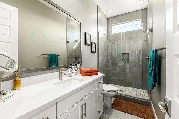 a bathroom with a sink a toilet and shower