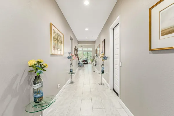 a hall with wooden floor and a potted plant