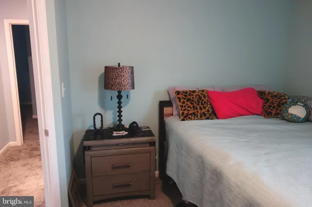 a bedroom with a bed and a lamp on dresser