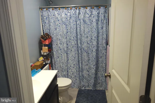 a bathroom with a toilet and a shower curtain
