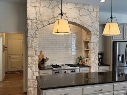 a kitchen with stainless steel appliances granite countertop a stove a sink and a microwave