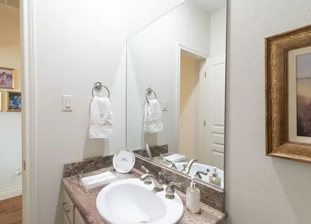 a bathroom with a granite countertop sink and a mirror