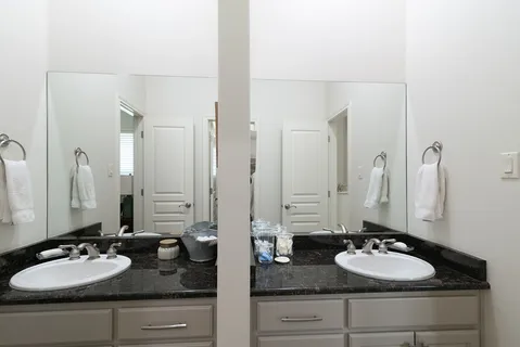 a bathroom with double vanity sinks and two mirror
