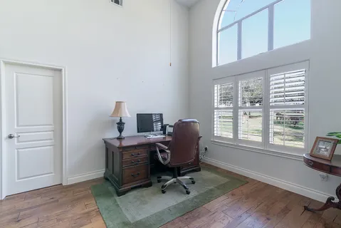 a view of a workspace with furniture and a window