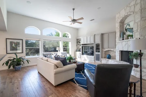 a living room with fireplace furniture and a large window