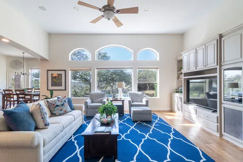 a living room with furniture a dining table and a large window