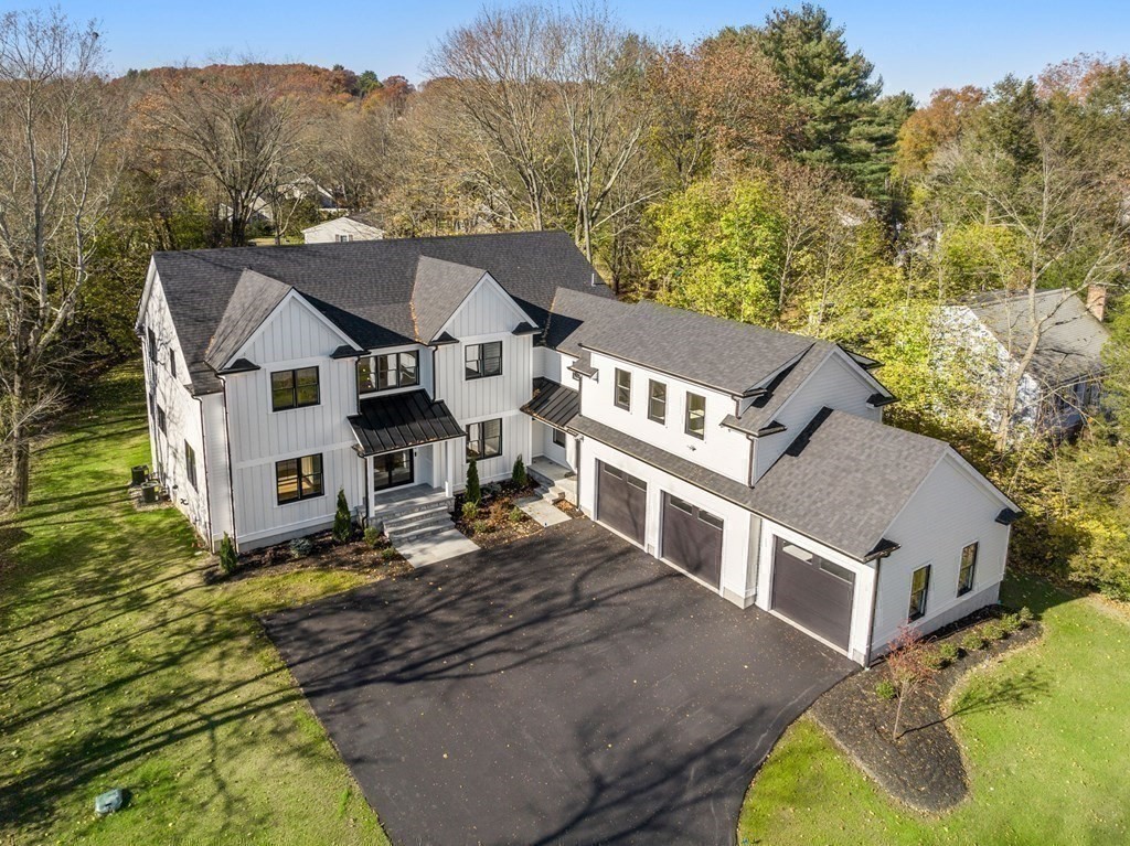 a aerial view of a house with a yard and large tree