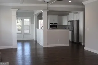 a view of kitchen with stainless steel appliances wooden floors and view living room