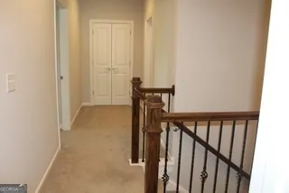 a view of a hallway with wooden floor and staircase
