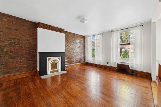 a view of empty room with wooden floor and fireplace