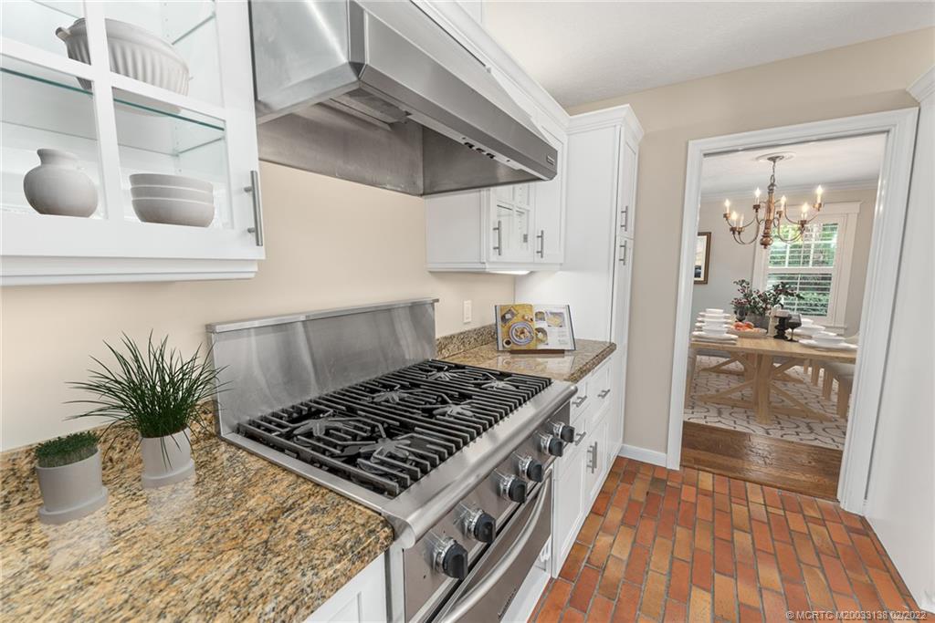 9 Middle Road Stuart, FL 34996 - Photo 14 of 32 a kitchen with kitchen island a counter space a stove and a wooden floors