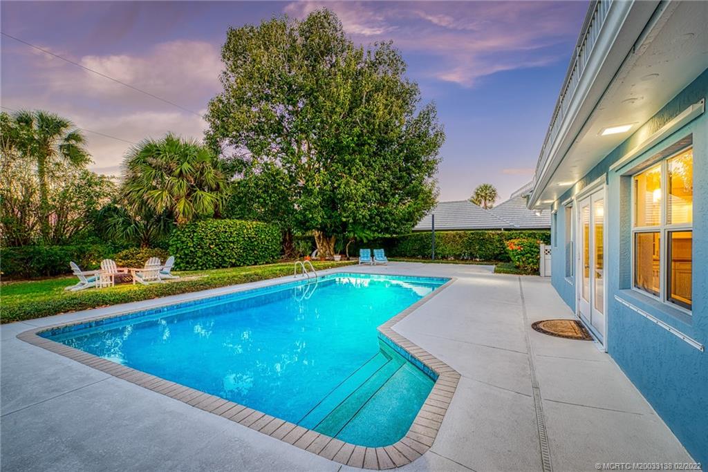 9 Middle Road Stuart, FL 34996 - Photo 4 of 32 a view of a swimming pool with an outdoor seating and a yard
