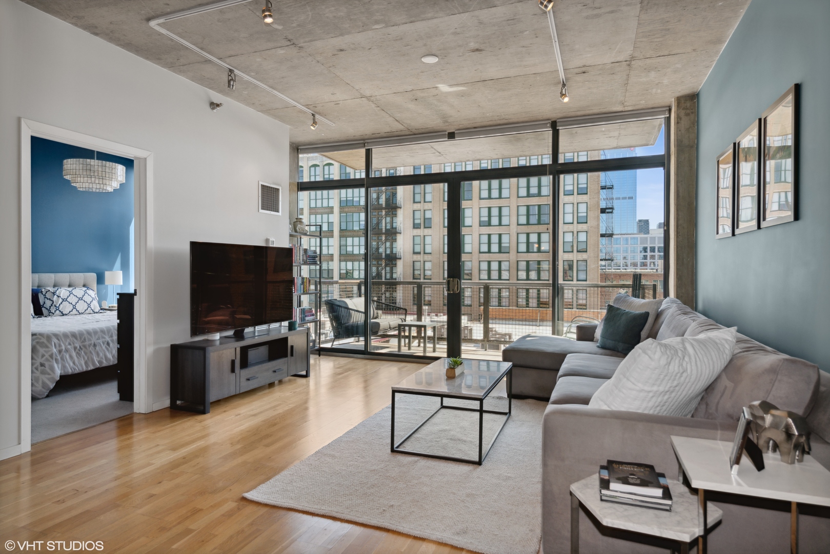 321 South Sangamon Street, Unit 810 Chicago, IL 60607 - Photo 2 of 14 a living room with furniture a flat screen tv and a large window