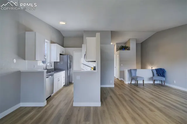 a kitchen with a wooden floor and a refrigerator