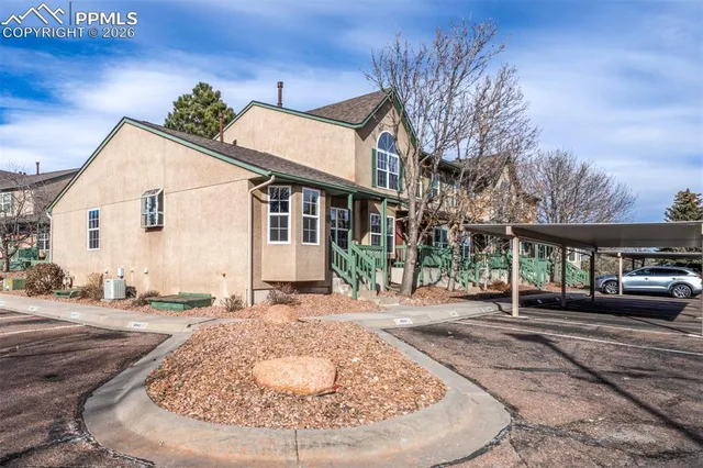 a view of a white house with a white walls and a yard