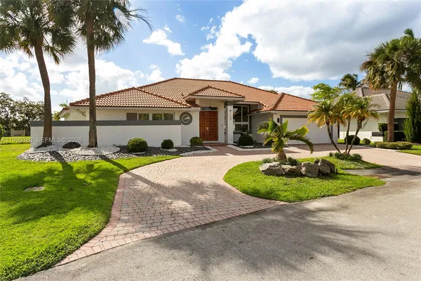 a front view of a house with garden and swimming pool