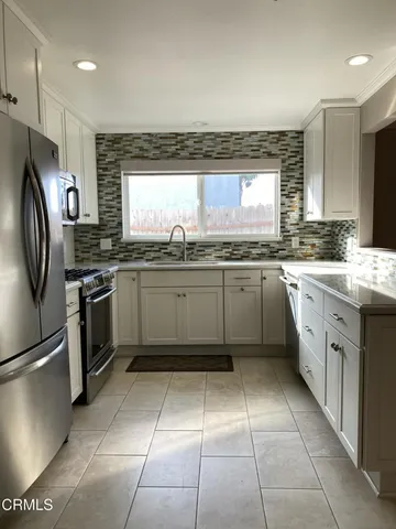 a kitchen with stainless steel appliances granite countertop a refrigerator stove a sink and dishwasher