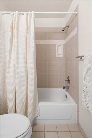 a white bath tub sitting next to a white toilet and a shower curtain