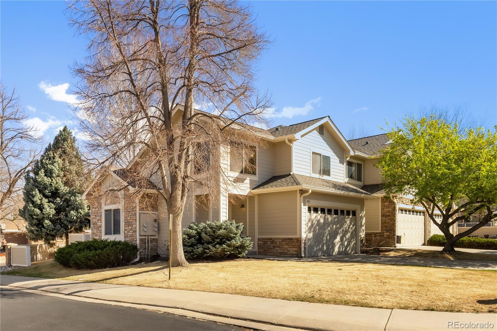 925 Hover Ridge Circle Longmont, CO 80501 - Photo 6 of 35 a view of a white house with large tree and plants
