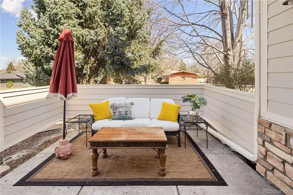 a roof deck with table and chairs and wooden floor